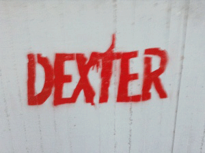 גרפיטי אדום עם המילה דקסטר על קיר לבן