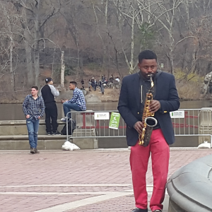 בחור שחור מנגן סקסופון בפארק