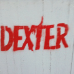 גרפיטי אדום עם המילה דקסטר על קיר לבן