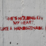 גרפיטי כתוב באדום על קיר לבן