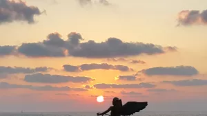 פסל של מלאך על רקע שקיעה